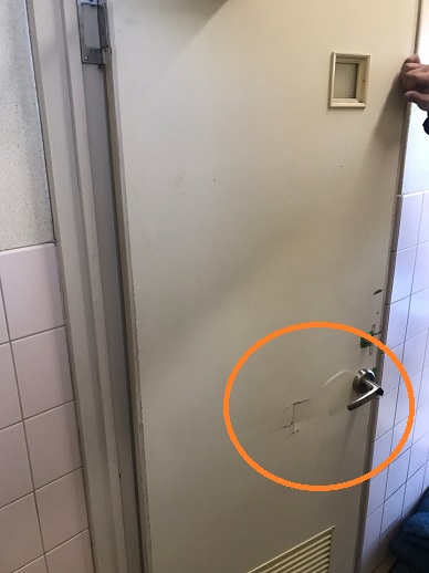 施工前、室内ドア（トイレ）の表面が割れている写真
